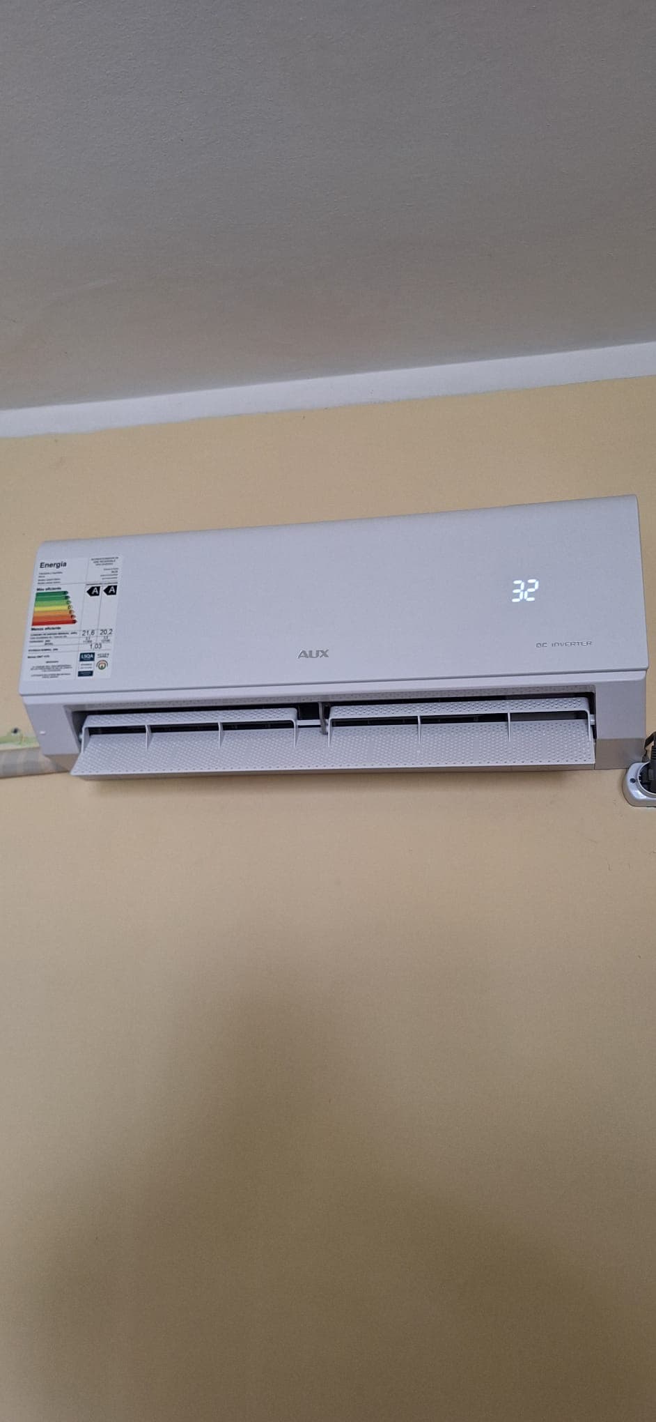Split AUX DC Inverter instalado en la pared de un ambiente y funcionando, con el visor marcando la temperatura.